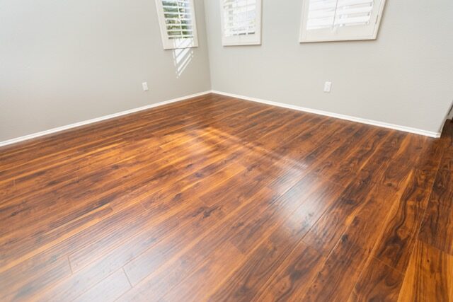 Refinished hardwood flooring in a rich walnut stain by ARK Renovation