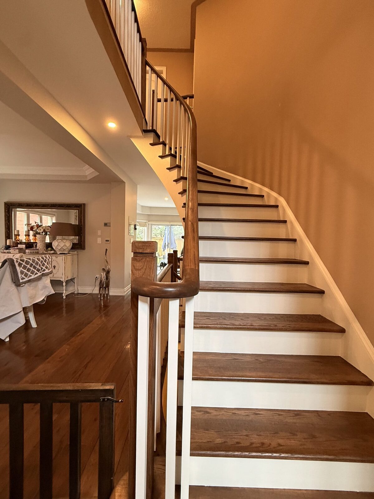 Curved staircase rebuild with oak treads and painted risers by ARK Renovation