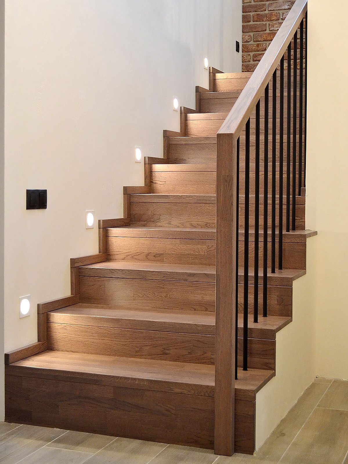 Custom oak staircase with built-in LED step lighting by ARK Renovation